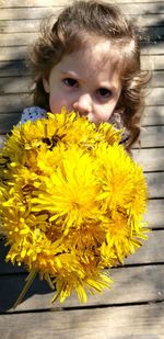 High angle portrait of girl with yellow flowers