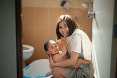 Portrait of mother and girl in bathroom