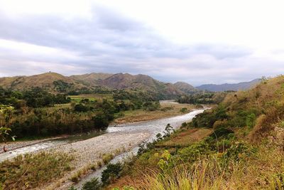 Scenic view of river against cloudy sky