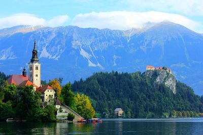 Lake bled by church against rocky mountains