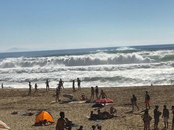 Panoramic view of people on beach against sky