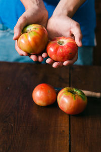 Cropped image of person holding fruits on table