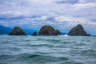 Rocks in sea against sky