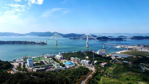 High angle view of city by sea against sky