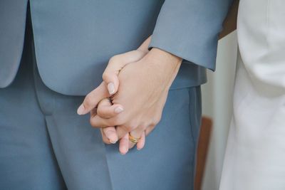 Midsection of couple holding hands