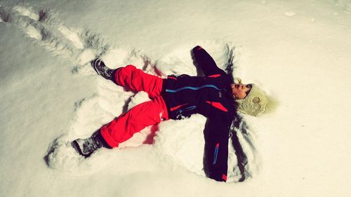 High angle view of girl making snow angel