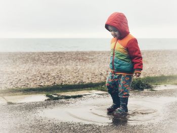 Full length of girl standing at beach against sky