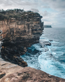 Rock formation on sea against sky