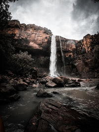 Scenic view of waterfall against sky