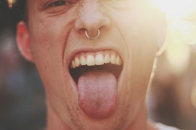 Close-up portrait of man sticking out tongue