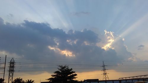 Low angle view of power lines against cloudy sky