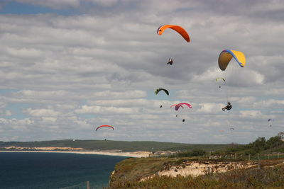 Low angle view of person paragliding over sea against sky