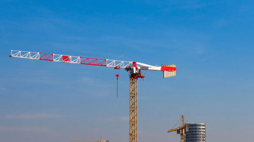 Low angle view of crane against sky