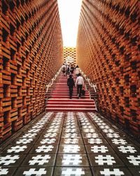 Rear view of people walking on tiled floor