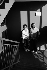 Portrait of friends standing against railing