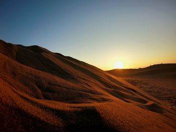 Scenic view of desert against sky during sunset