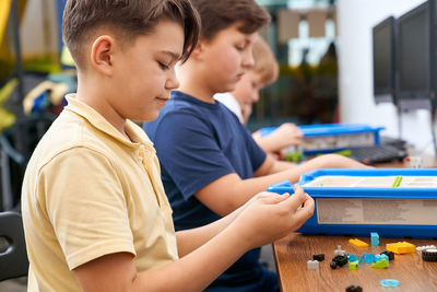 Side view of boy looking at table