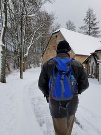 Rear view of man on snow covered landscape during winter