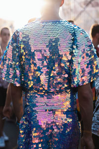 Rear view of woman standing against multi colored umbrella