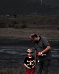 Portrait of father and son standing on shore