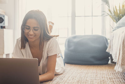 Young woman using laptop while sitting at home