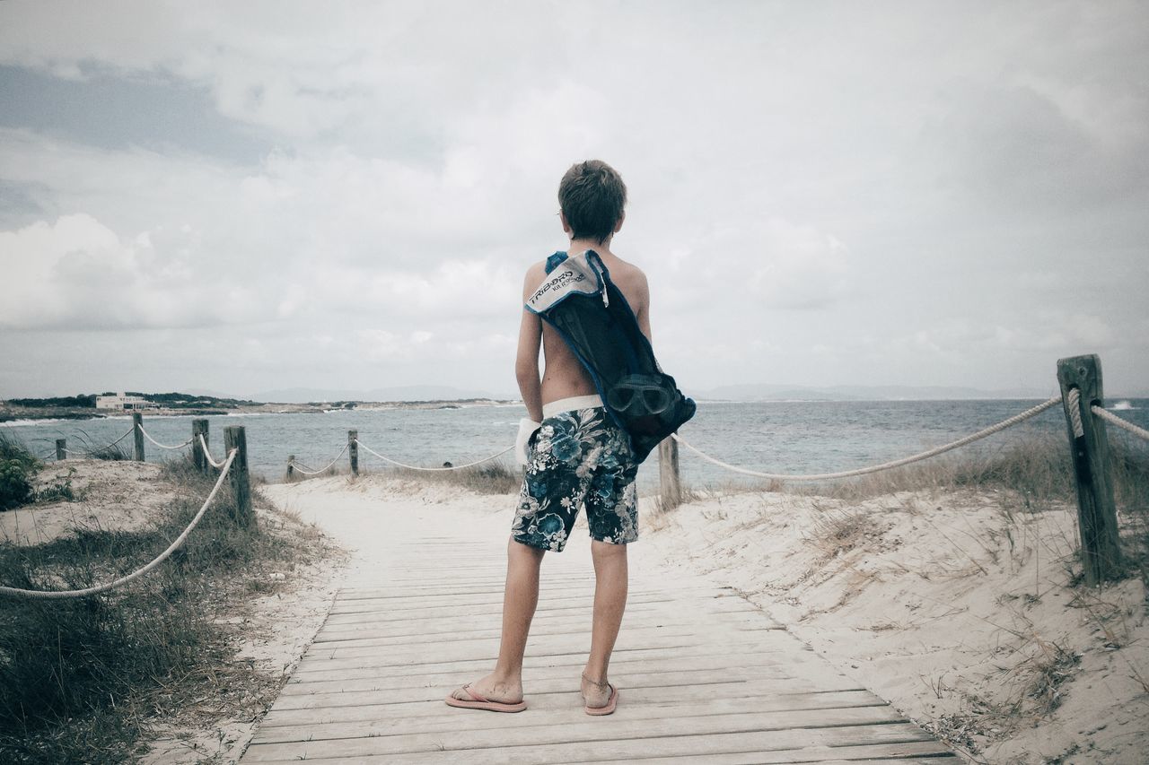 full length, rear view, sky, sea, beach, horizon over water, casual clothing, lifestyles, water, standing, leisure activity, sand, shore, walking, tranquil scene, tranquility, cloud - sky, nature