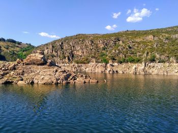 Scenic view of rocks in lozoya river against sky