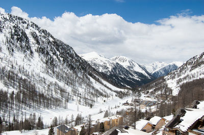 Panoramic view of snow covered mountains against sky