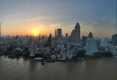 City at waterfront during sunset