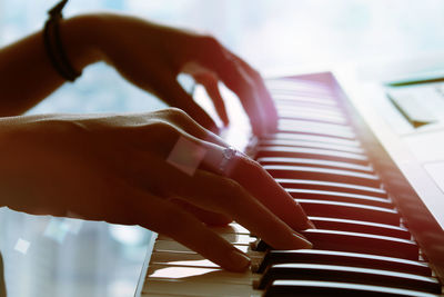 Close-up of woman hands playing piano