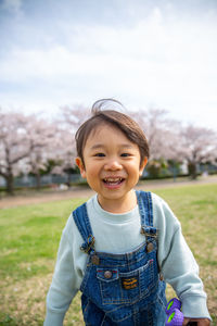 Portrait of girl standing against trees