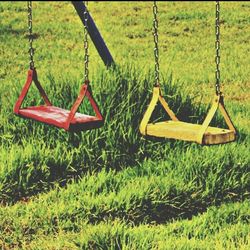 Empty swing on grassy field