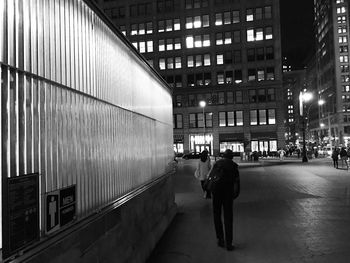 People walking on illuminated street at night