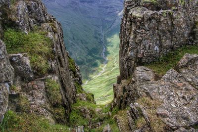 Scenic view of waterfall by mountains against sky