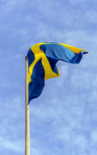 Low angle view of flag against blue sky