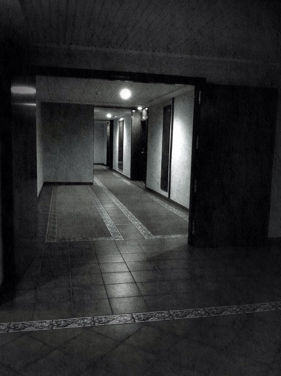 architecture, built structure, illuminated, building exterior, night, the way forward, empty, building, indoors, street, corridor, door, wall - building feature, lighting equipment, entrance, flooring, no people, window, walkway, absence