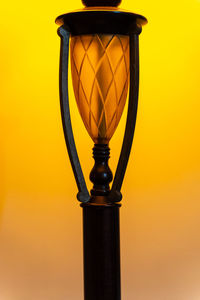Close-up of illuminated street light against orange sky