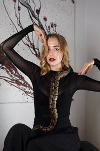Portrait of smiling young woman holding snake