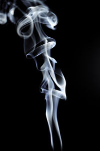 Close-up of emitting smoke against black background