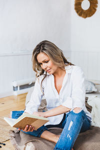 Beautiful young woman sitting at home