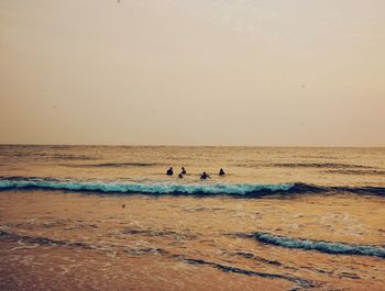 Scenic view of beach against clear sky during sunset