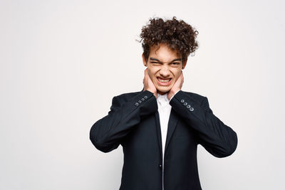 Portrait of smiling young man against white background