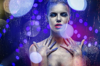 Seductive naked woman with glitter against blue background