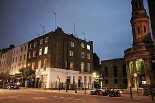 LOW ANGLE VIEW OF ILLUMINATED BUILDING AT NIGHT