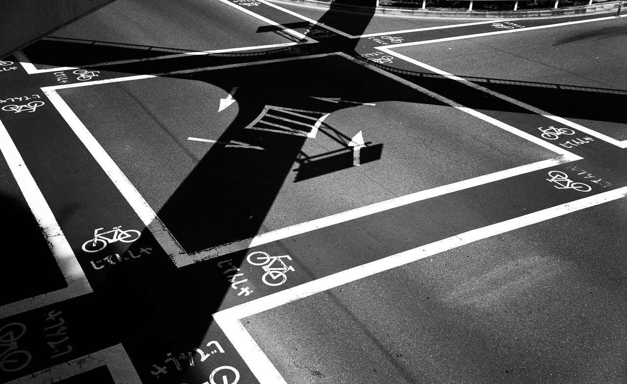 high angle view, communication, road marking, text, road, transportation, street, guidance, western script, asphalt, arrow symbol, indoors, close-up, number, directional sign, technology, shadow, zebra crossing, capital letter, part of