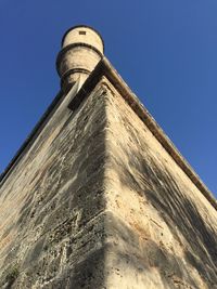 Low angle view of water tower against clear blue sky