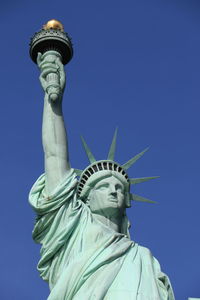 Low angle view of statue against blue sky