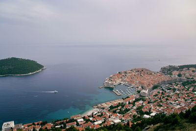 High angle view of townscape by sea against sky