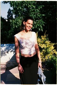 Smiling woman standing against plant