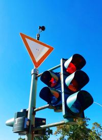 Low angle view of road sign against blue sky